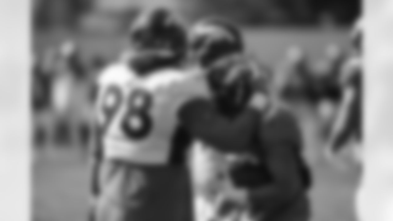 Mike Purcell gives a hug to Phillip Lindsay during the 14th day of training camp at UCHealth Training Center on September 1, 2020. (Photo by Ben Swanson)