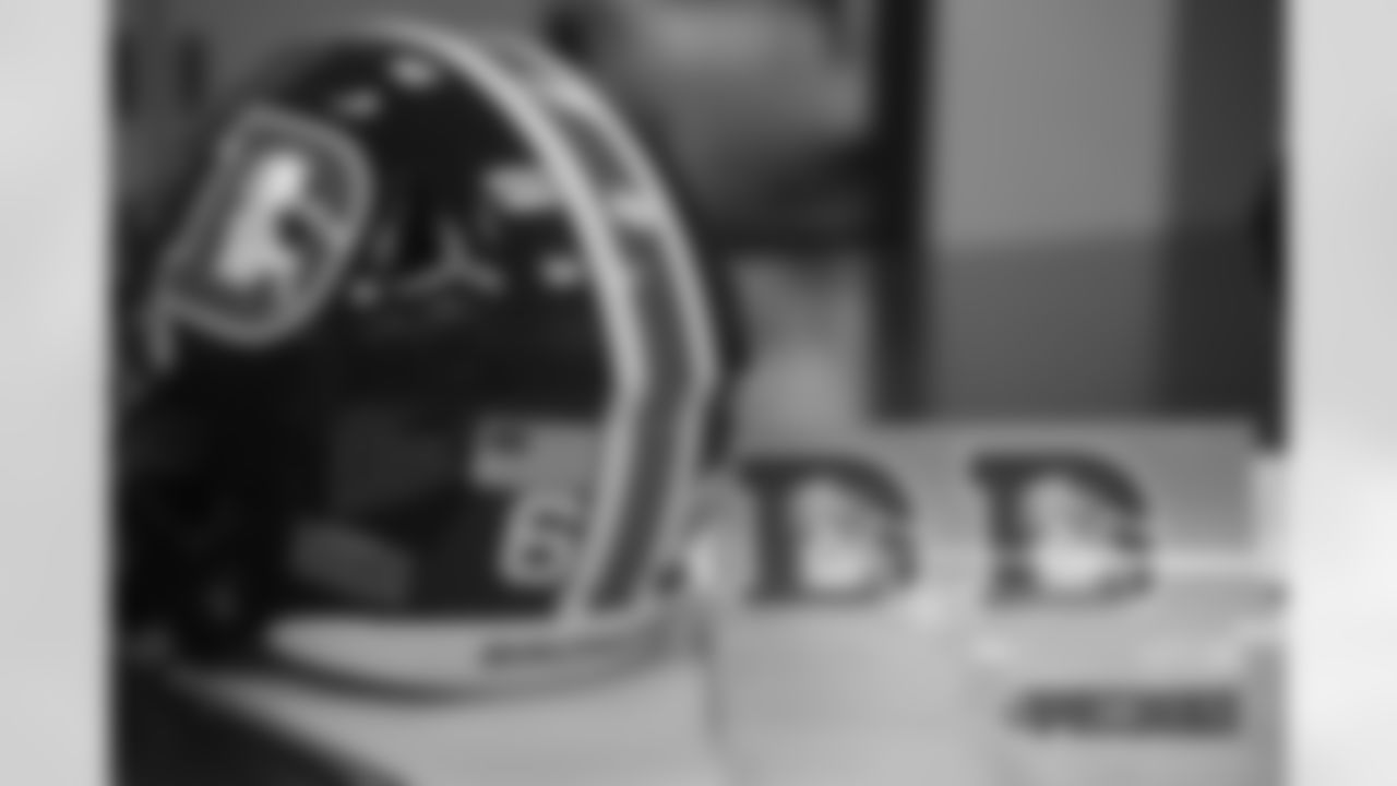 Inside the Broncos' equipment room as staffers transition helmets to the team's Color Rush set, applying new decals and throwback logos for the team's Week 12 game.