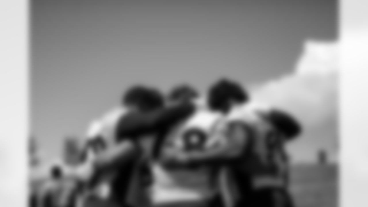 Malik Reed, Derrek Tuszka and Andre Mintze huddle up with other outside linebackers during the seventh day of OTA practices at UCHealth Training Center on June 7, 2021. (Photo by Ben Swanson)