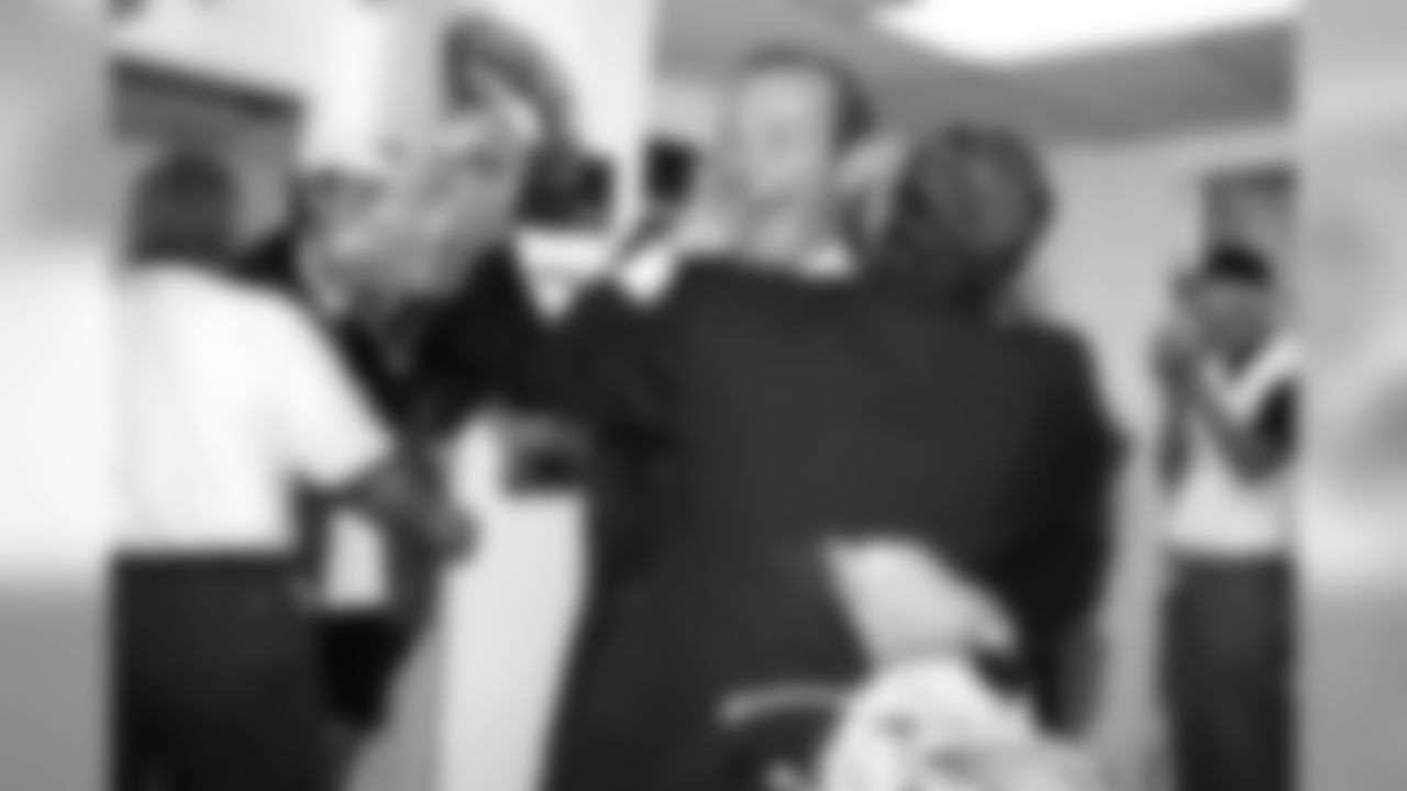 Owner Pat Bowlen hugs Media Relations Director Jim Saccomano as he enters the locker room holding the Vince Lombardi Trophy during the post-game celebration against the Green Bay Packers at Qualcomm Stadium in San Diego, CA on January 25, 1998.