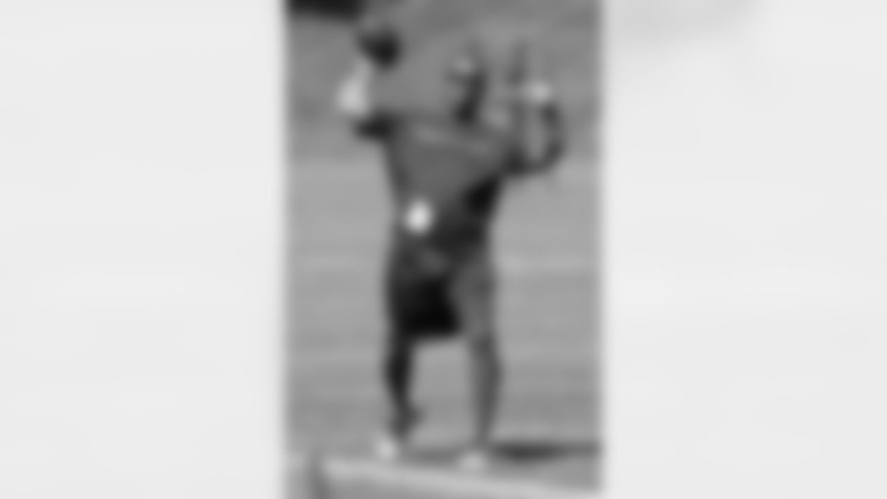 WR Coach Tyke Tolbert throws a pass during practice.