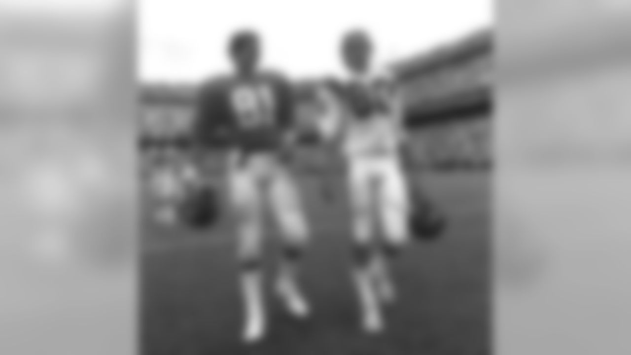 Wide receiver Steve Watson leaves the field with Bengals receiver Cris Collinsworth after a September 2, 1984 win (20-17) over Cincinnati at Mile High Stadium.