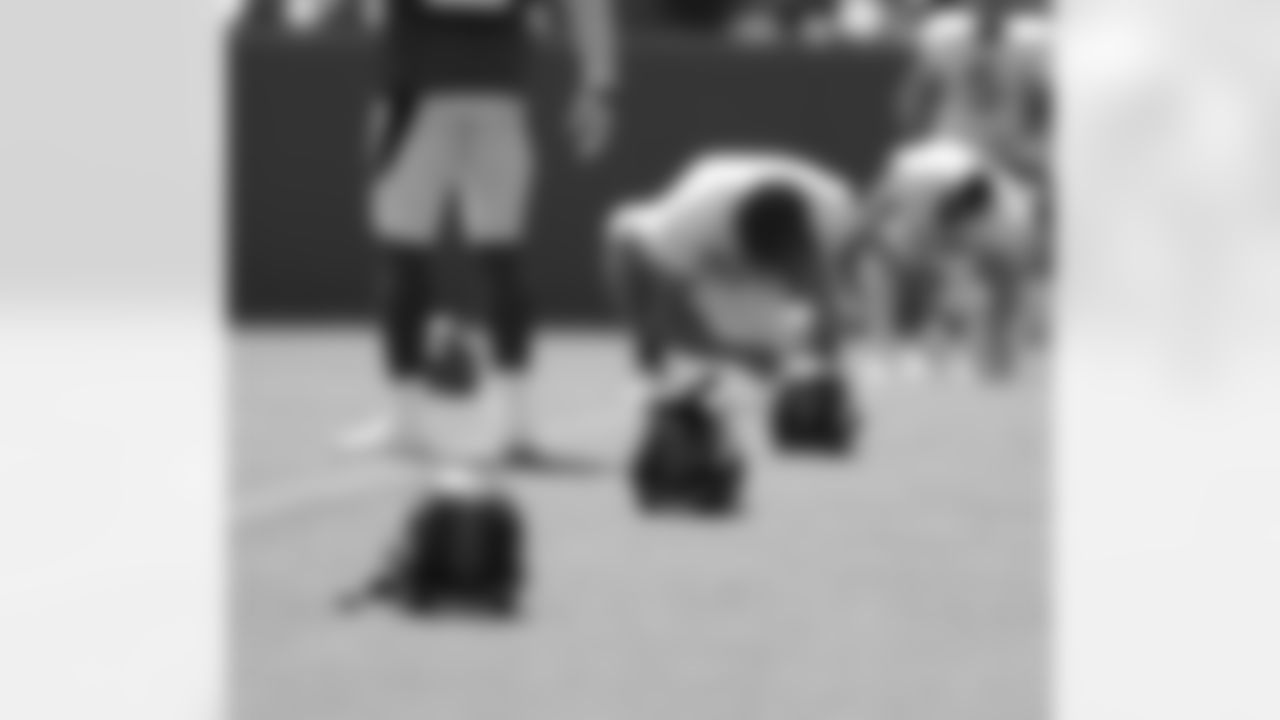 Helmets sit on the field as the team gets stretched out before practice.