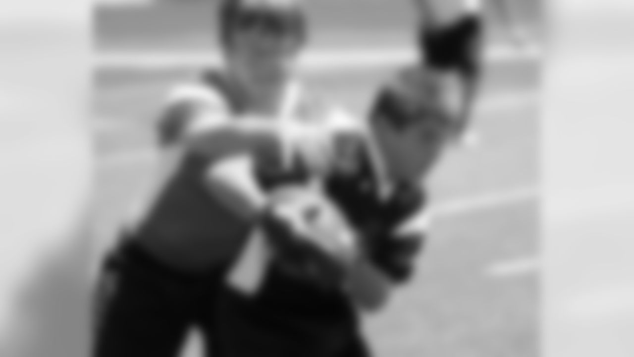 The ball carrier tries to fight through a tackle.