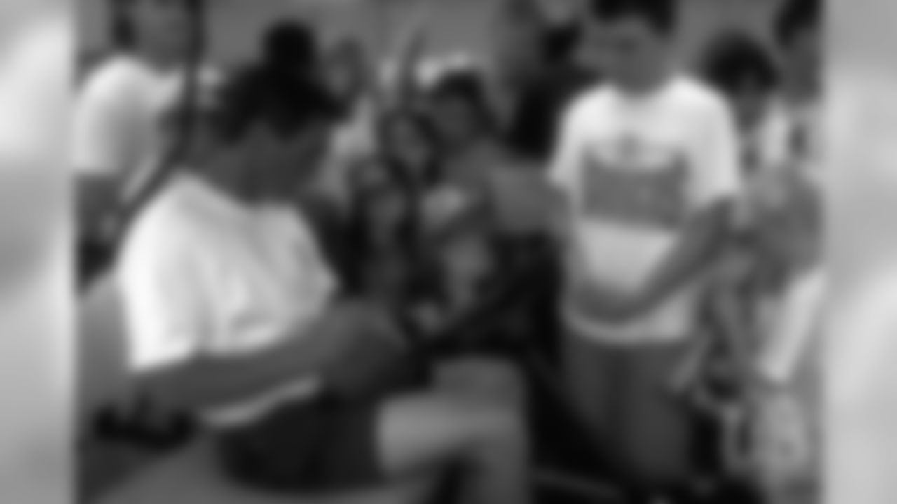 Coach Mike Shanahan signs autographs for fans at 1995 training camp.