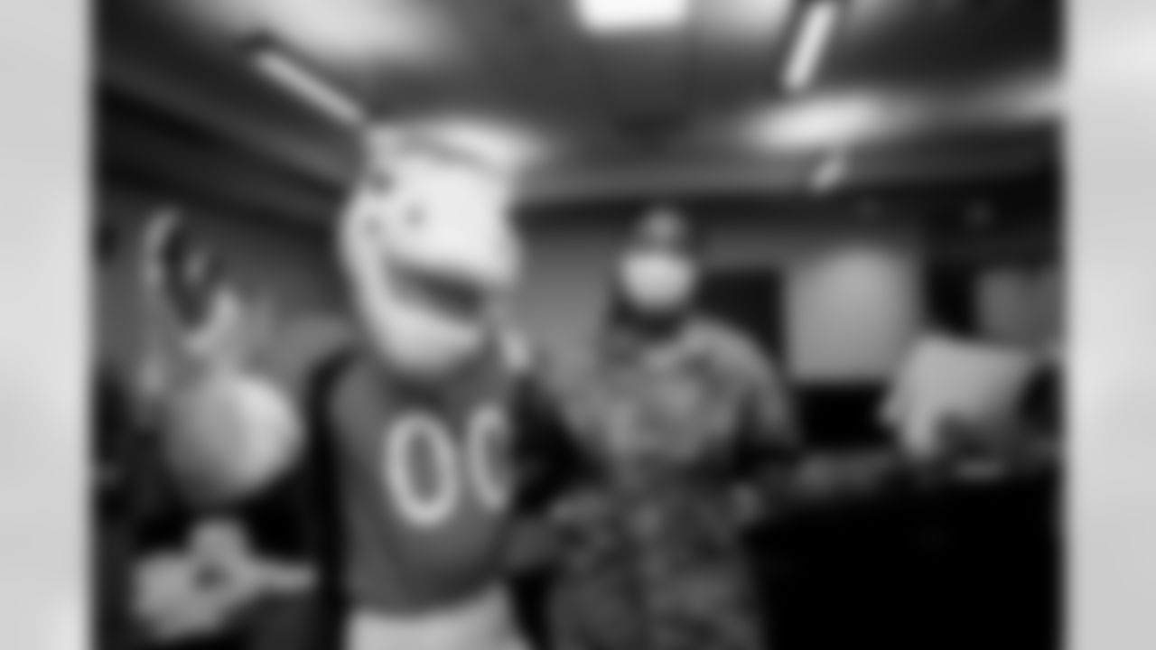 Miles the mascot poses for a photo with a military member during the Salute to Service Caravan presented by USAA at Buckley Space Force Base in Aurora, Colorado on November 2, 2021. (Photo by Ben Swanson)