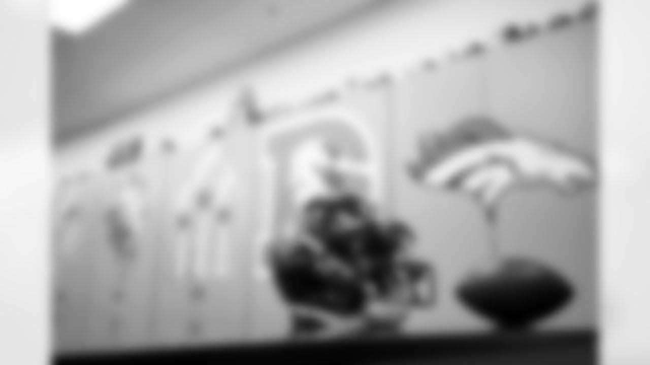 Members of the equipment staff place Color Rush decals on players' helmets at UCHealth Training Center in Englewood, Colorado on November 9, 2021. (Photo by Ben Swanson)