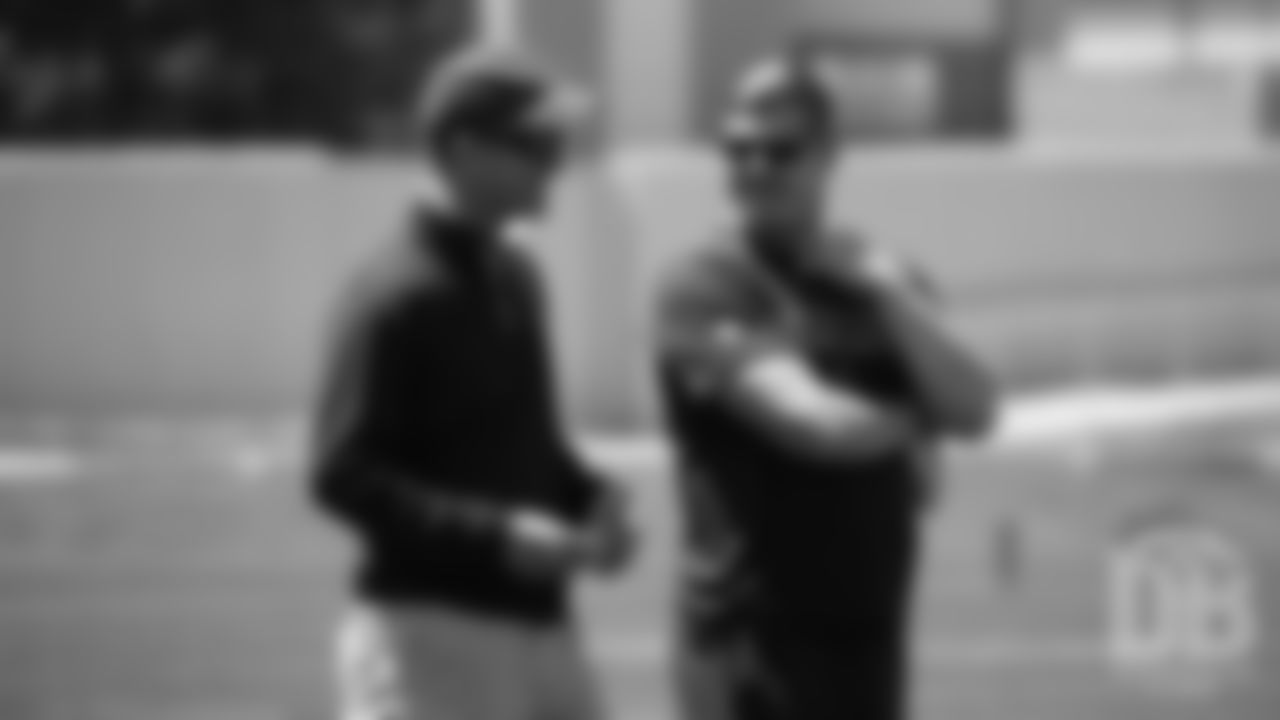 Assistant Offensive Line Coach Chris Kuper talks with former Broncos quarterback Peyton Manning during the Broncos' practice on the eight day of their OTAs on May 30, 2019.