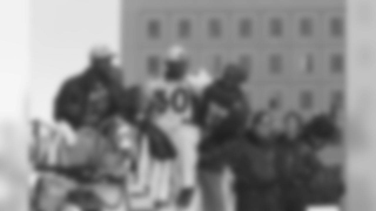 Terrell Davis and teammates ride on a fire truck during the team's second Super Bowl parade through downtown Denver.