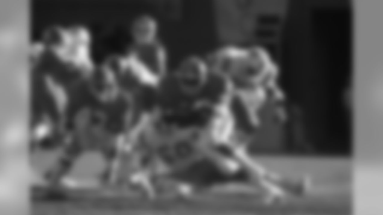 Sammy Winder breaks upfield in a cloud of dust against the Patriots.