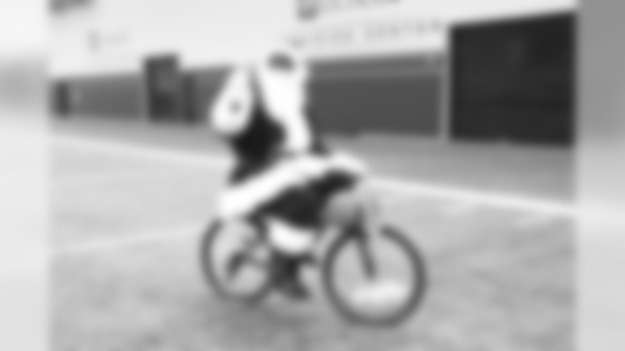 Outside linebacker DeMarcus Ware (94), aka DeMarcus Claus, rides a bike at the Boys & Girls Club holiday Party in the Pat Bowlen Fieldhouse on December 20, 2016. Ninety club members were welcomed for a party with free bicycles. (Caroline Deisley)