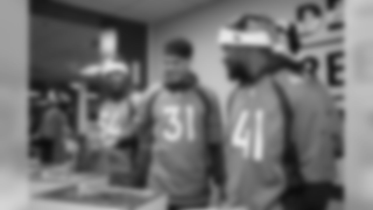 Josh Watson, Justin Simmons, De'Vante Bausby and teammates serve dinner at the Denver Rescue Mission's 20th annual holiday party at the Mission's The Crossing location on December 9, 2019. (Photo by Ben Swanson)