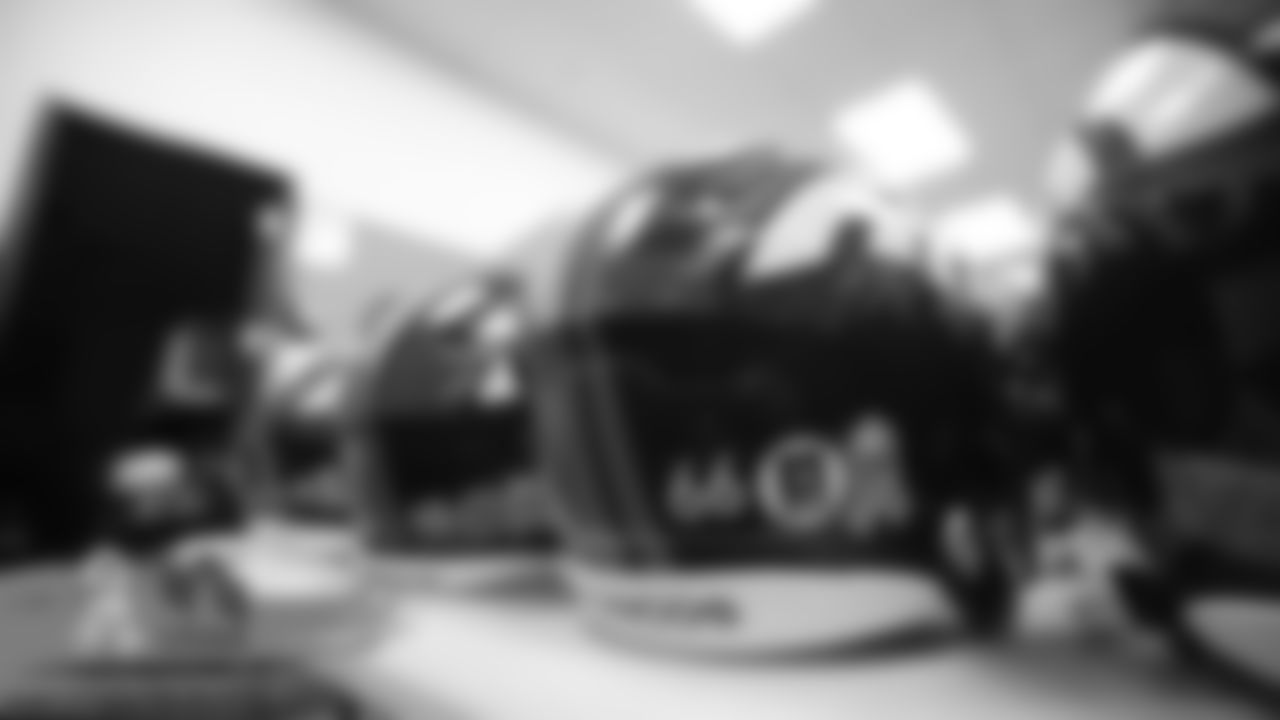A helmet sticker for the U.S. Army is applied to Dalton Risner's helmet in the equipment room at UCHealth Training Center for Salute to Service month on October 31, 2019. (Photo by Ben Swanson)