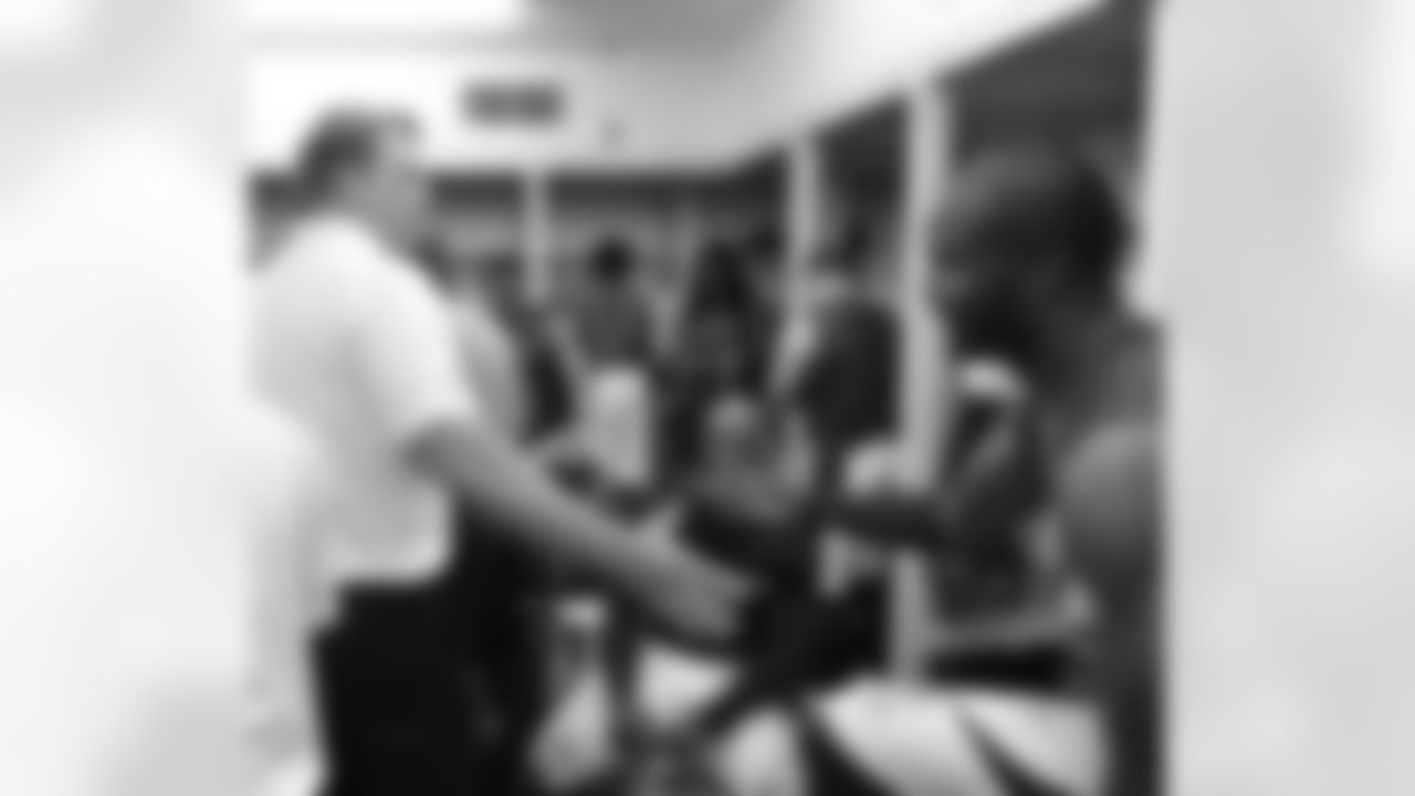 Defensive Coordinator Jack Del Rio shakes hands with veteran cornerback Champ Bailey in the locker room.