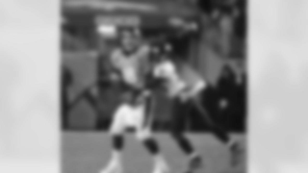 Manning is hit as he releases a pass.