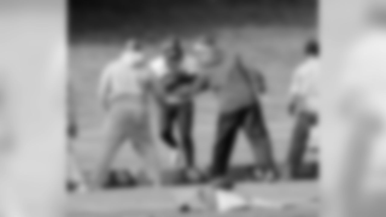 Running Backs Coach Eric Studesville and Offensive Coordinator Mike McCoy try to knock the ball loose from a player.