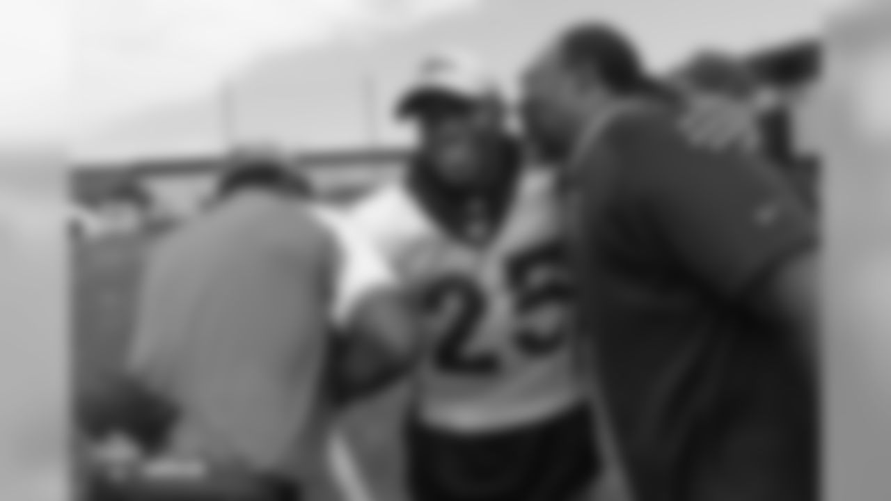 cornerback Chris Harris Jr. (25) greets Ring of Fame former safety Billy Thompson and a Broncos alumnus during the 10th day of training camp on August 8, 2018, at UCHealth Training Center.