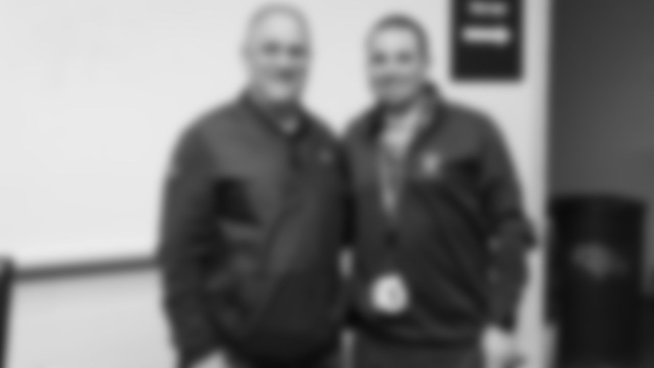 Head Coach Vic Fangio poses for a photo with a raffle winner at a meet-and-greet visit with team employees at Broncos Stadium at Mile High on March 19, 2019.