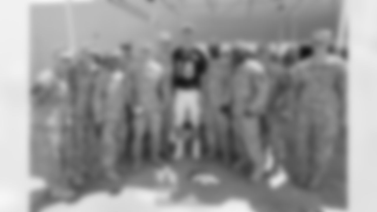 Manning poses for a photo with the servicemen and women from Fort Carson.