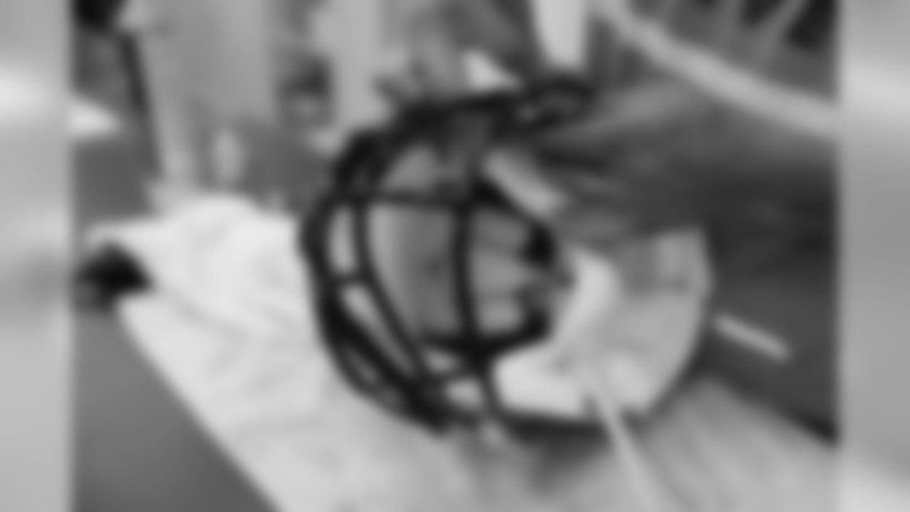 Assistant equipment manager Kenny Chavez works on a helmet.