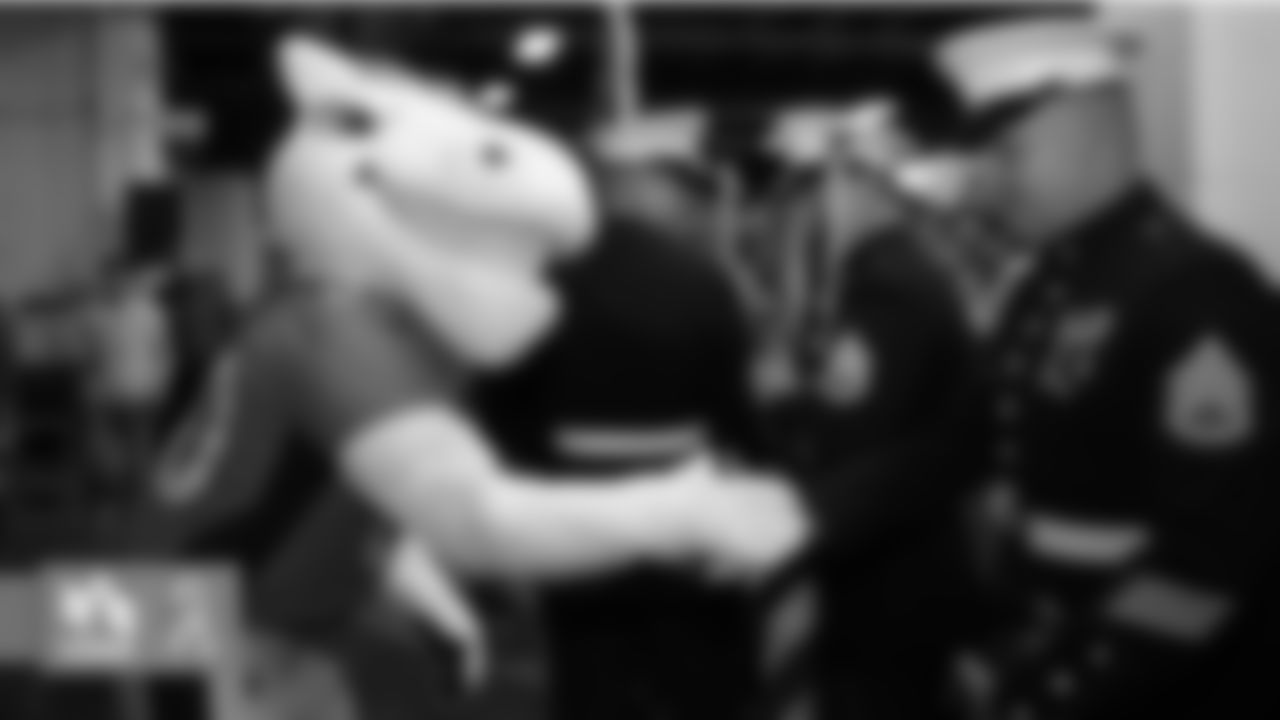 Miles the mascot greets military members in the tunnel before the Broncos' game against the Cleveland Browns at Empower Field at Mile High on November 3, 2019. (Photo by Ben Swanson)