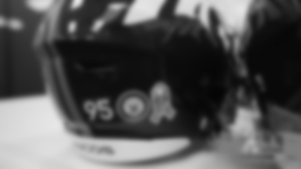 A helmet sticker for the U.S. Navy is applied to Derek Wolfe's for Salute to Service month on October 31, 2019. (Photo by Ben Swanson)