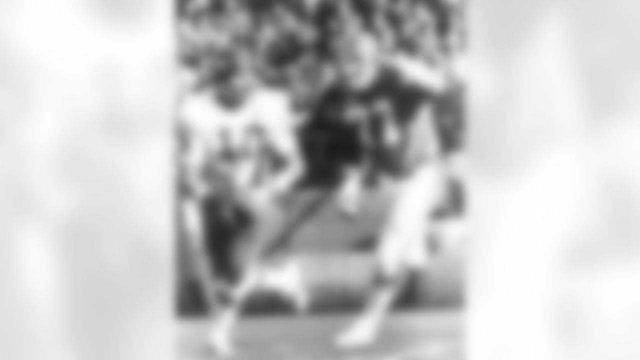 Lyle Alzado chases Chiefs quarterback Mike Livingston during a game at Mile High Stadium.