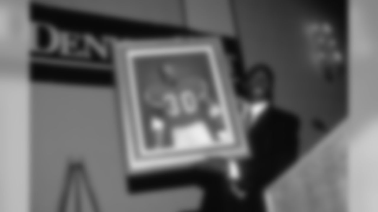 Running back Terrell Davis holds up a portrait of himself at the 1997 Athlete of the Year ceremony.