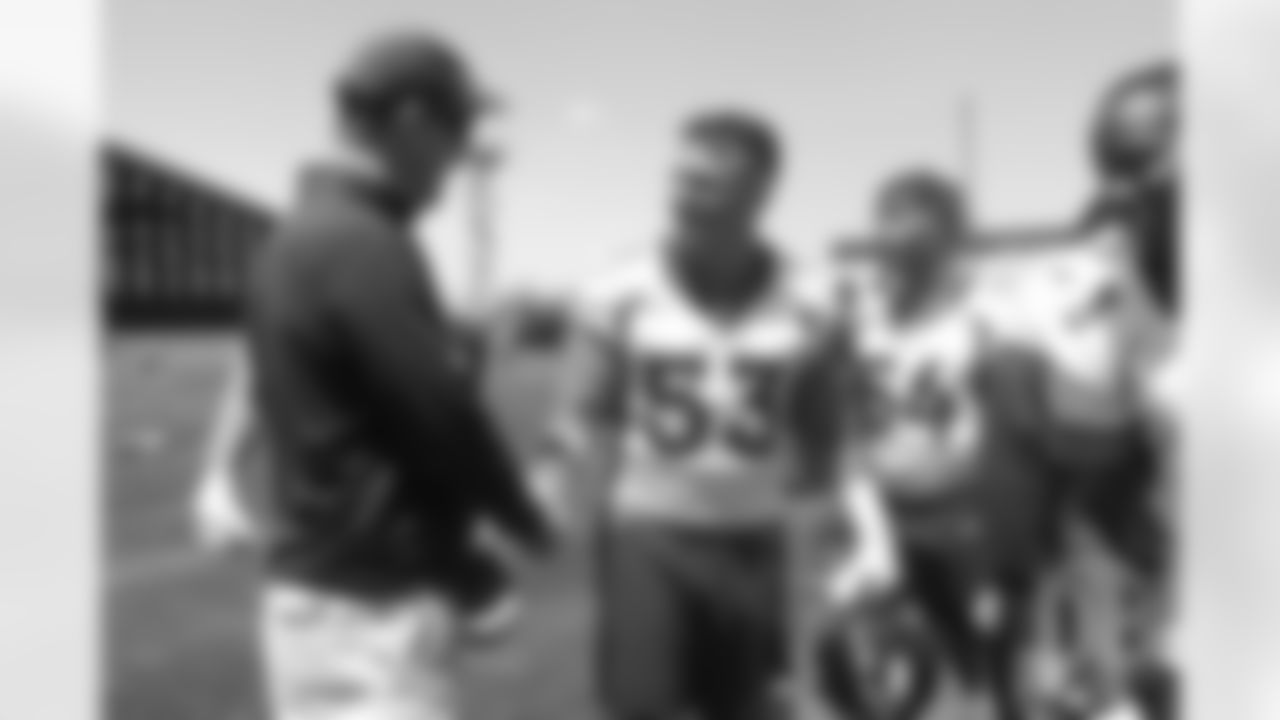 Joe Dineen greets former Broncos quarterback Peyton Manning after the Broncos' practice on the eight day of their OTAs on May 30, 2019.