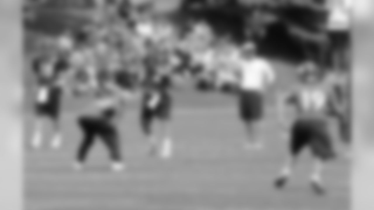 QB Adam Weber throws a pass as Manning and Offensive Coordinator Mike McCoy look on.