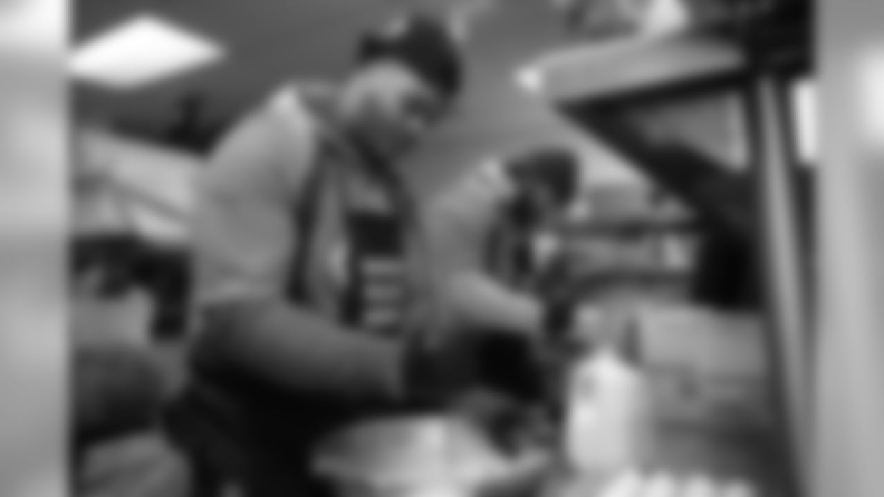 Elijah Wilkinson and other members of the offensive line help prepare Thanksgiving meals at Denver Rescue Mission's Lawrence Street Community Center on November 25, 2019. (Photo by Ben Swanson)