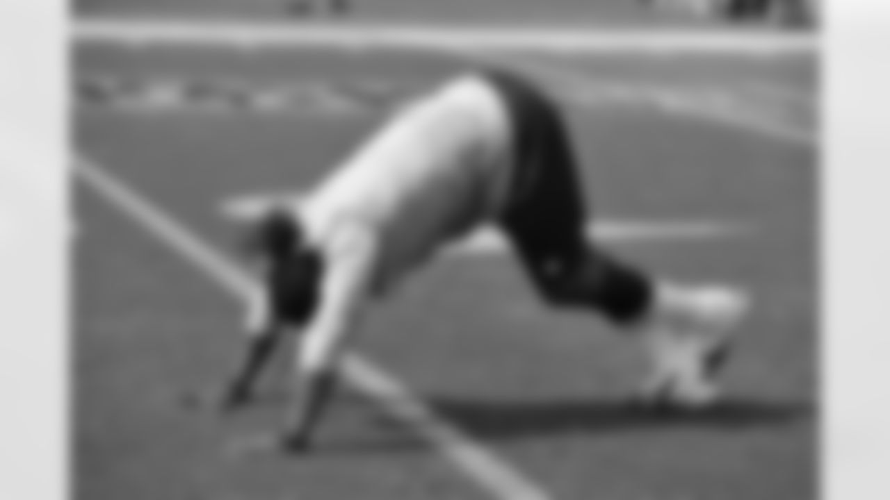 Rookie LB Danny Trevathan stretches his calves on the field before the game.