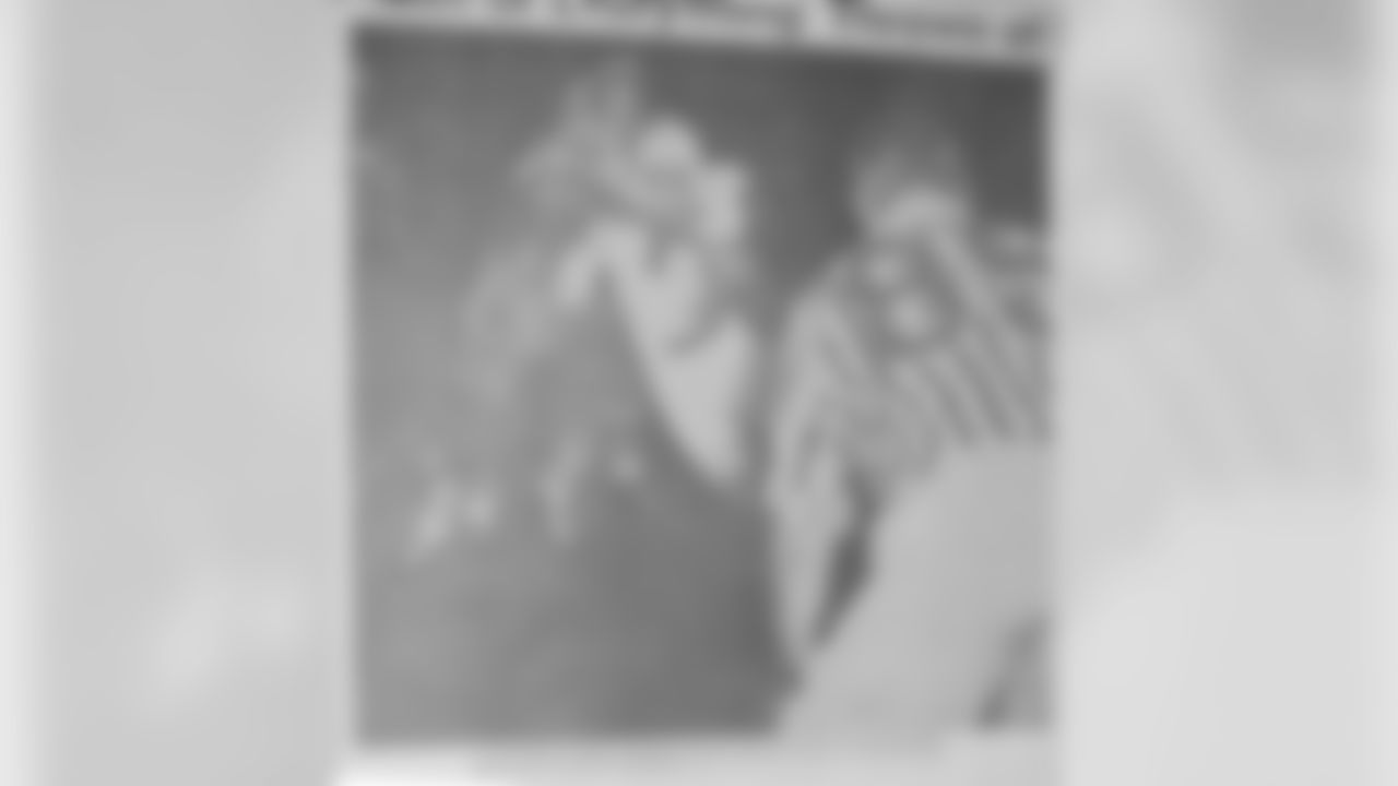 Newspaper photo of Parseghian breaking a Len Ford tackle for a touchdown.