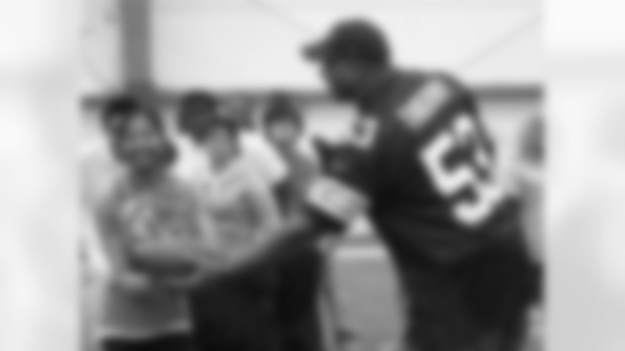 Cleveland Browns Alumni John Thierry (1999) hands off to a Special Olympics Participant