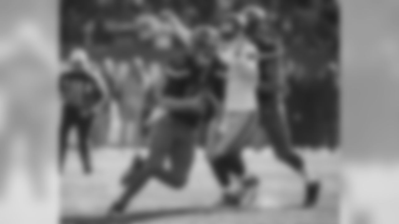 QB Josh McCown avoids a tackle as he runs with the ball.