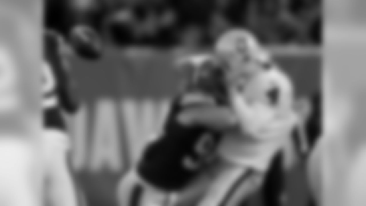 Oakland Raiders quarterback Derek Carr (4) is hit by Cleveland Browns outside linebacker Paul Kruger in the third quarter of an NFL football game Sunday, Oct. 26, 2014, in Cleveland. (AP Photo/Tony Dejak)