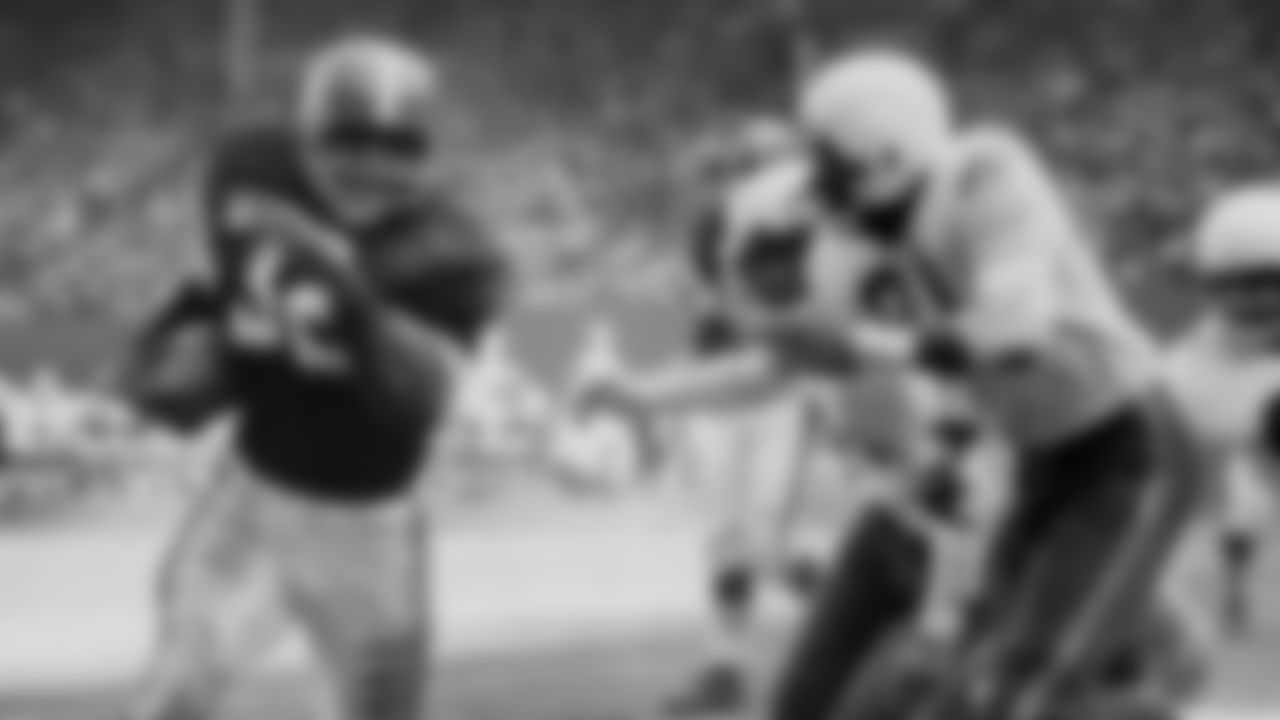 Browns running back Jim Brown (left) carries the ball during a game.