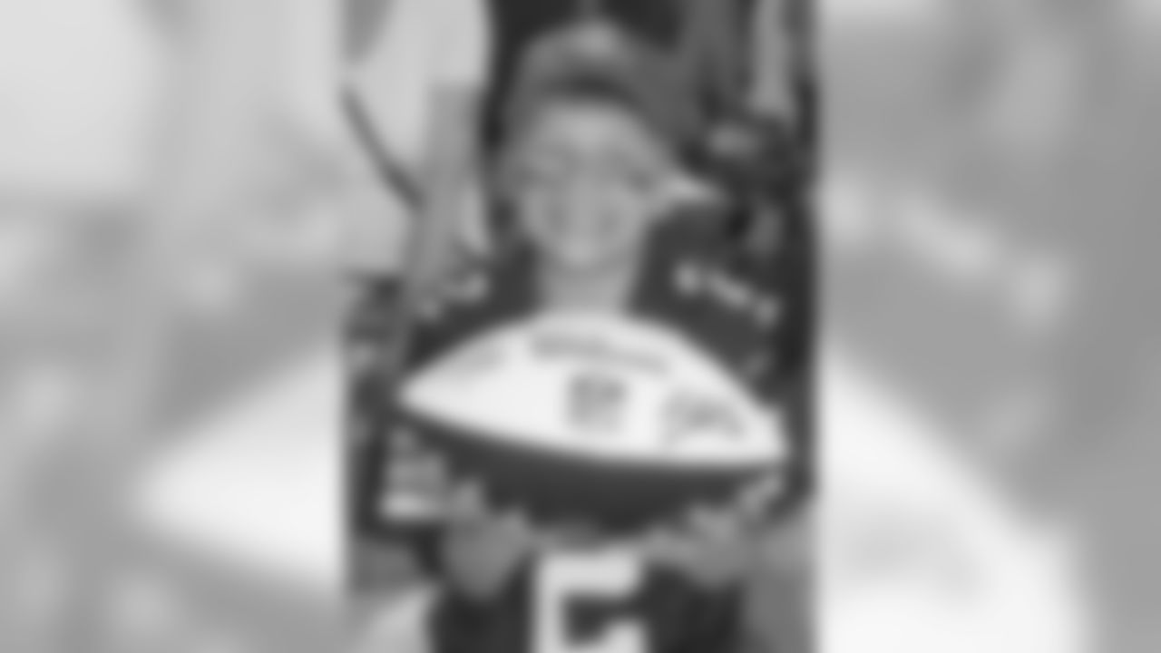 A young fan shows off his autographs from training camp.