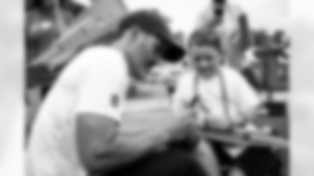 Offensive guard Wyatt Teller (77) signs autographs for fans during the twelfth day of training camp at CrossCountry Mortgage Campus on August 14, 2022.