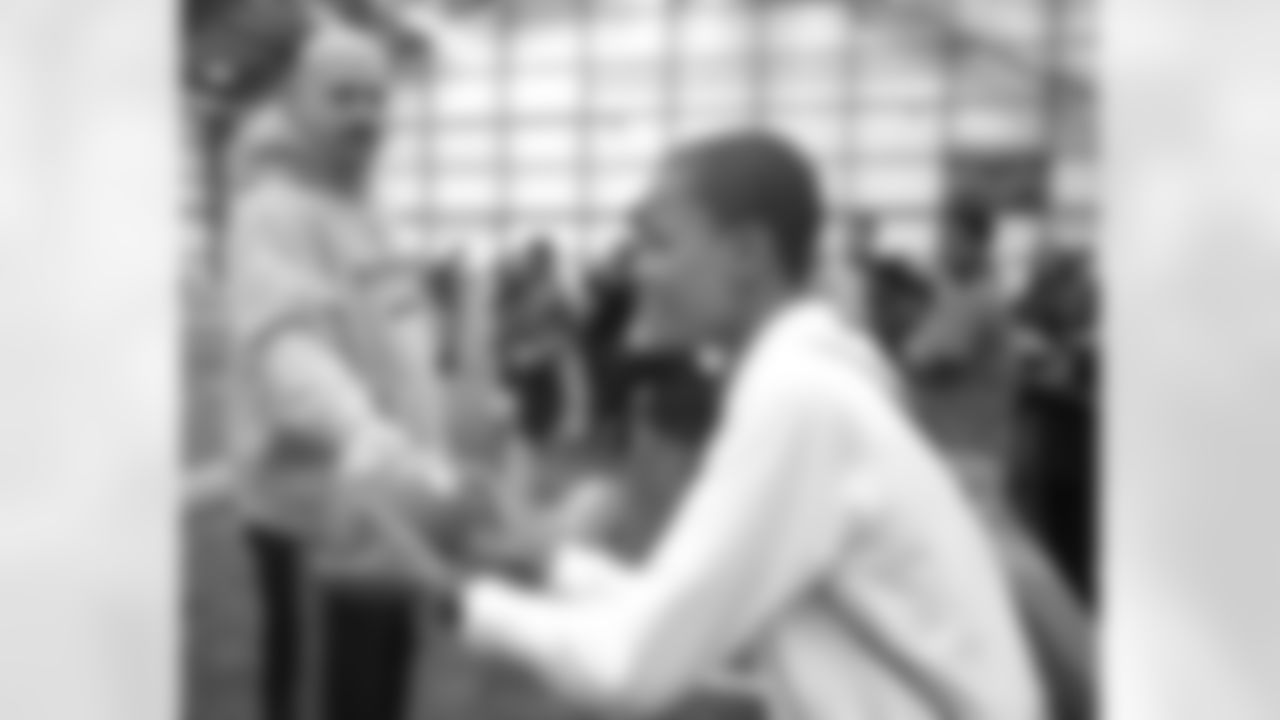 Cleveland Browns Head Coach Mike Pettine hands off to a Special Olympics participant