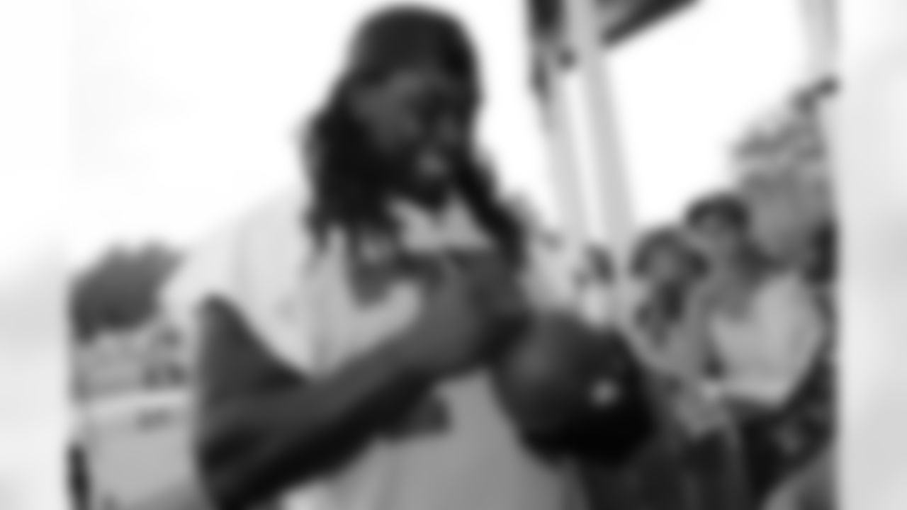 G Davin Joseph flashes his trademark big smile while signing autographs