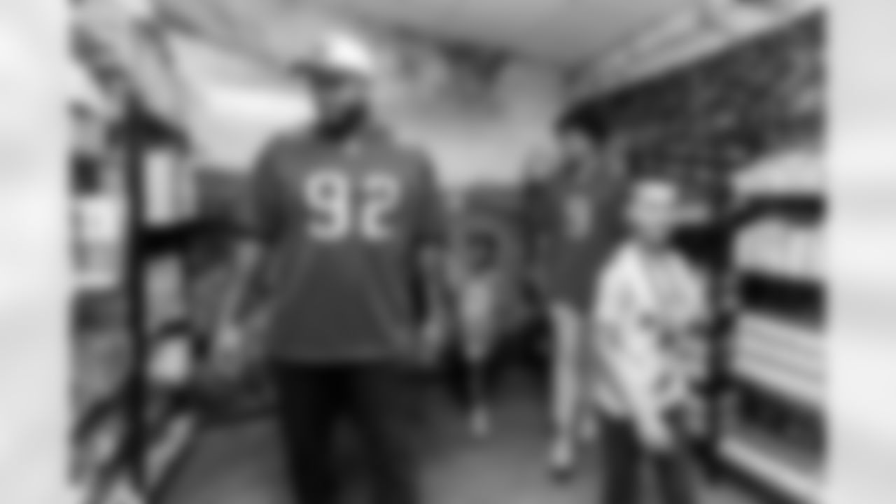 TAMPA, FL - November 29, 2022 - Outside Linebacker Joe Tryon-Shoyinka #9 and Defensive Lineman William Gholston #92 of the Tampa Bay Buccaneers with a student during the Mosaic Food Pantry opening at Jack R. Lamb Elementary. Photo By Kyle Zedaker/Tampa Bay Buccaneers