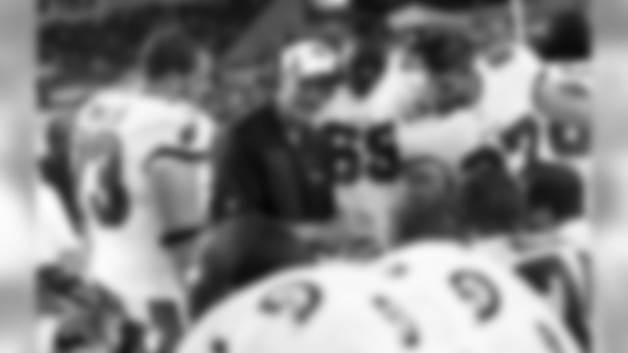 Offensive line coach Bob Bostad goes over photos with his players on the sidelines of the 8/8 preseason game.
