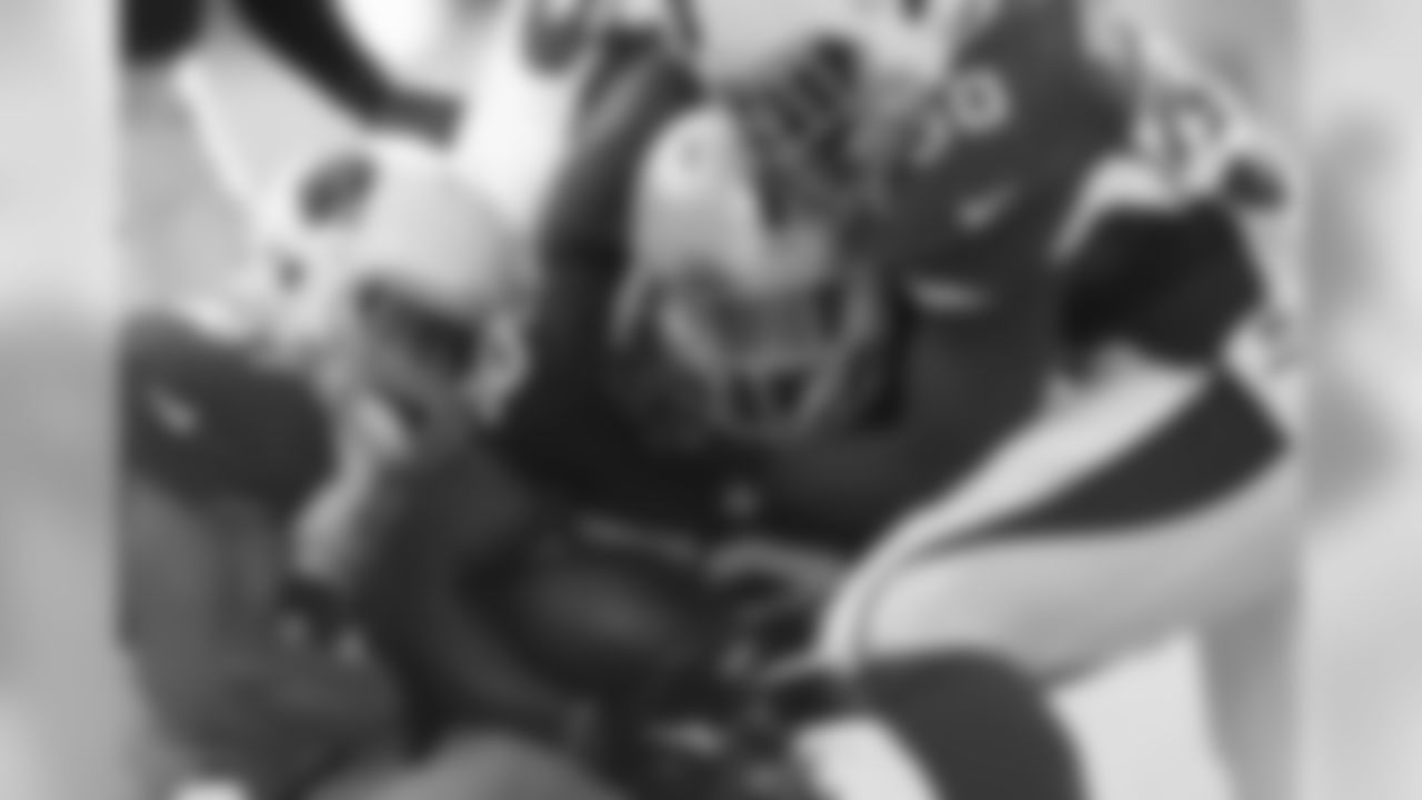 LB Lorenzo Alexander (left) and RB Stepfan Taylor sandwich Raiders returner T.J. Carrie