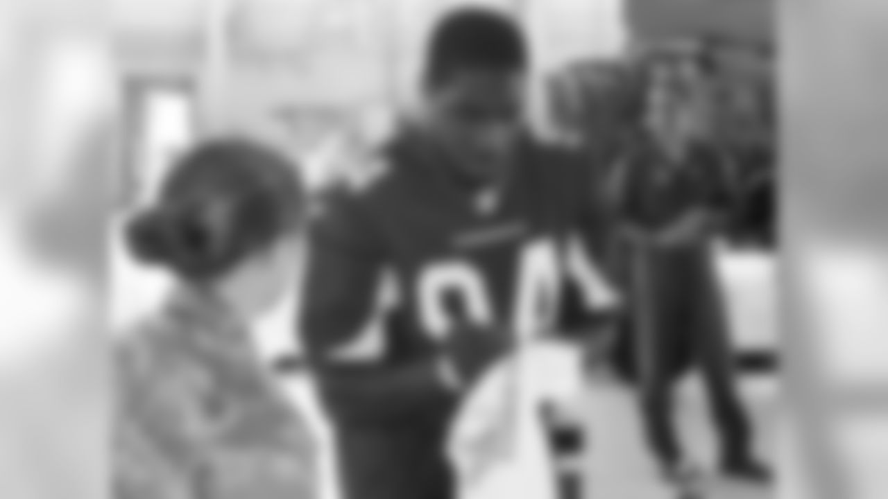 Sam Acho signs an autograph for a military member.