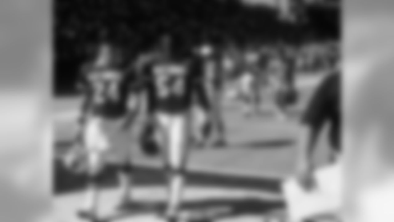 1987: Ron Wolfley walks off the field with Lawrence Taylor