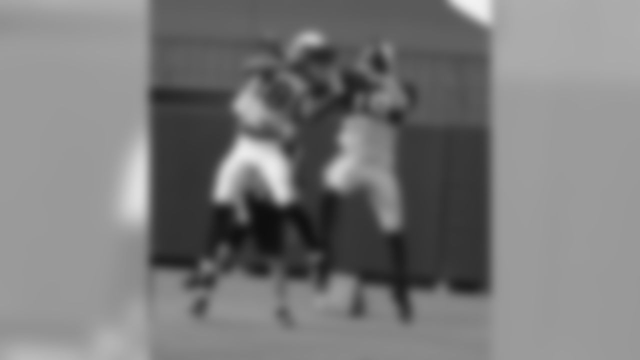 CB Justin Bethel (left) and WR Ted Ginn battle for a pass
