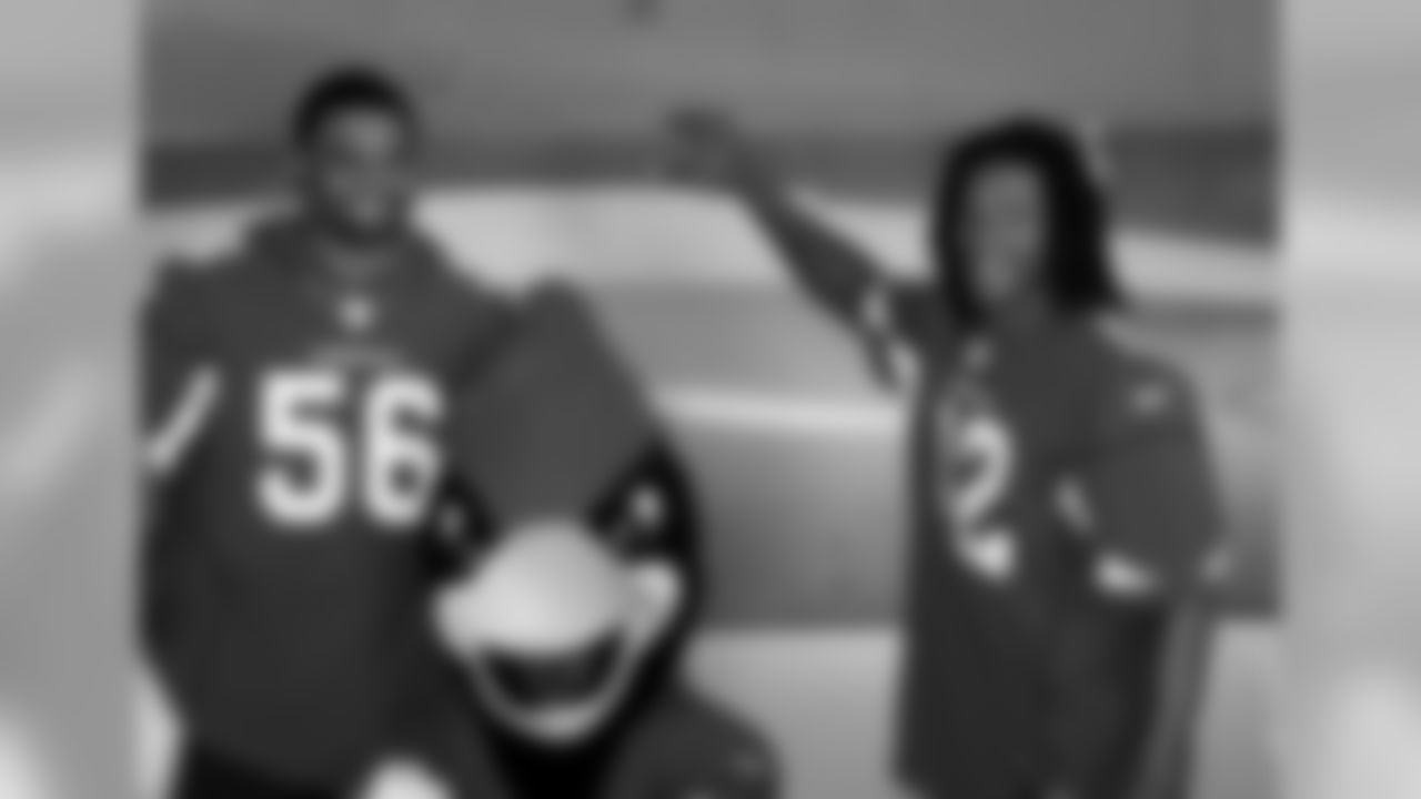 Karlos Dansby (left), Big Red and Andre Roberts take a photo in front of an F-16.