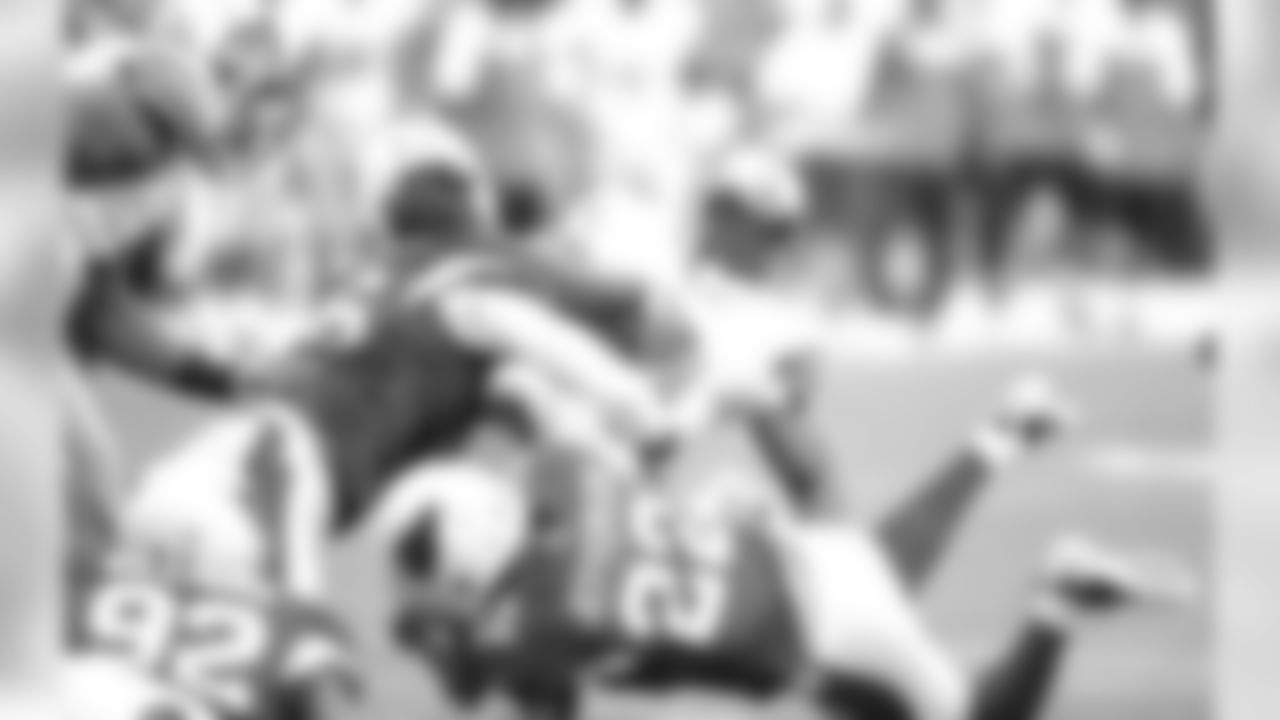 S Tony Jefferson and DE Ronald Talley tackle Lions RB Reggie Bush.