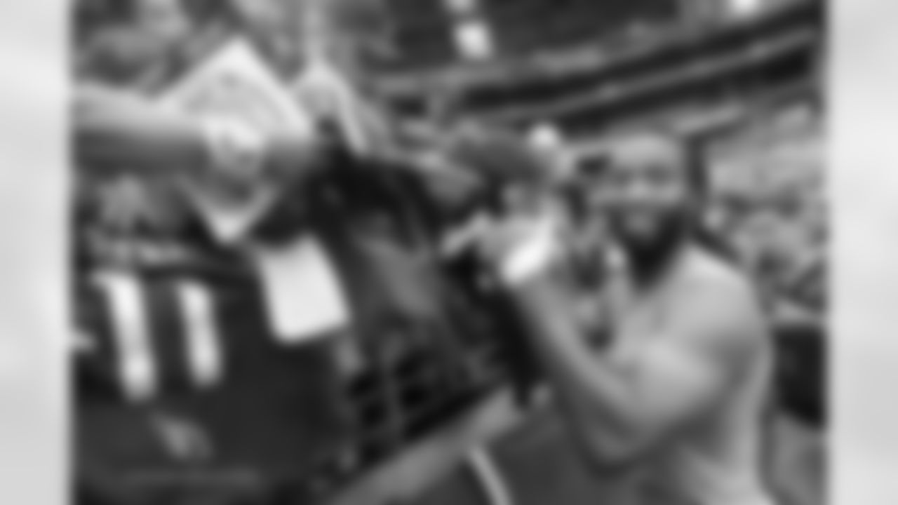 WR Larry Fitzgerald smiles while signing autographs for fans